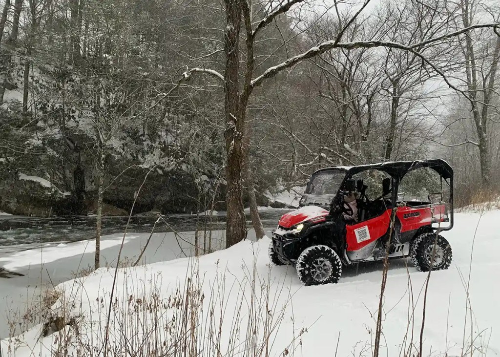Red UTV beside a snow-covered creek after Winter Storm Gianna in Gatlinburg
