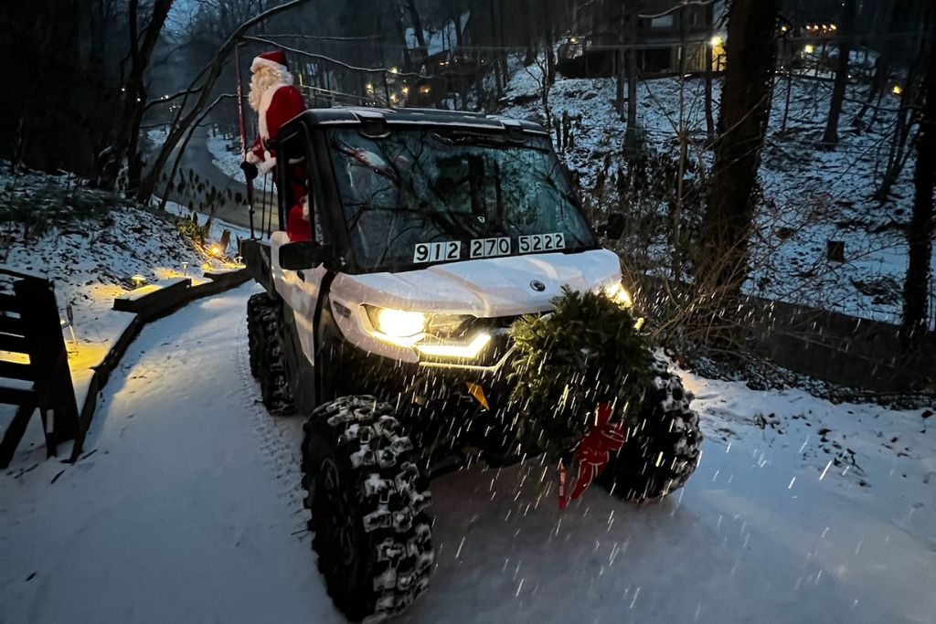 white UTV through the snow at night near Smoky Mountain cabins during a winter holiday adventure