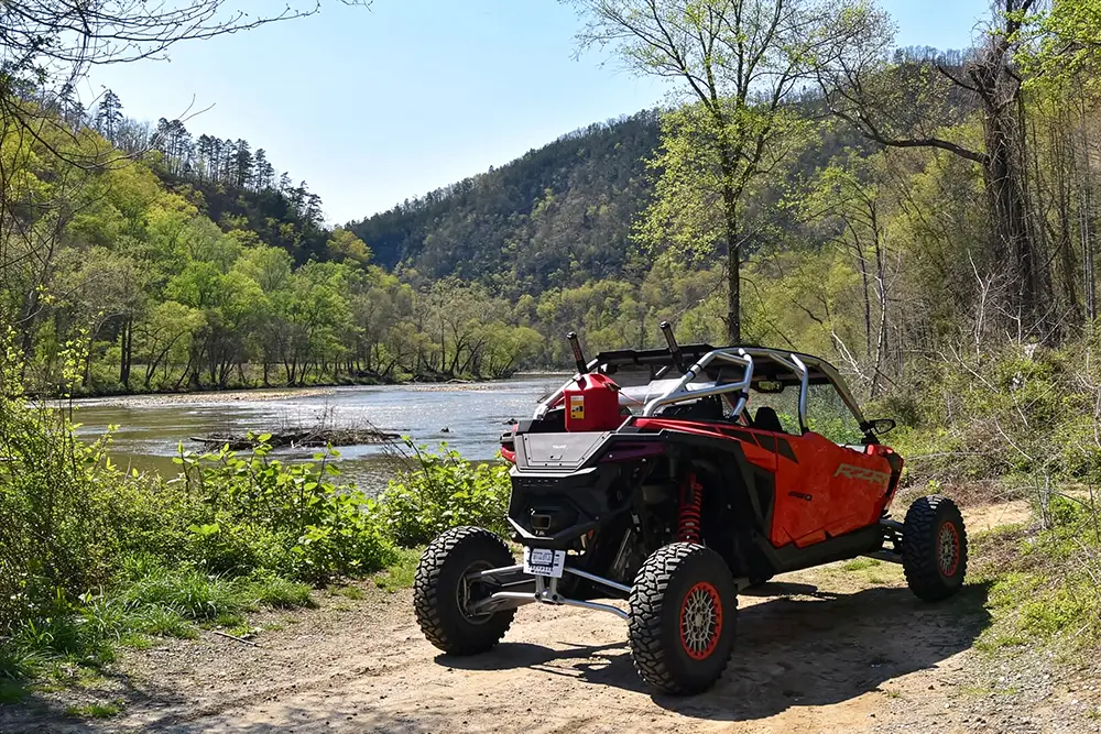 Street-legal UTV parked beside a river on a scenic Smoky Mountains trail