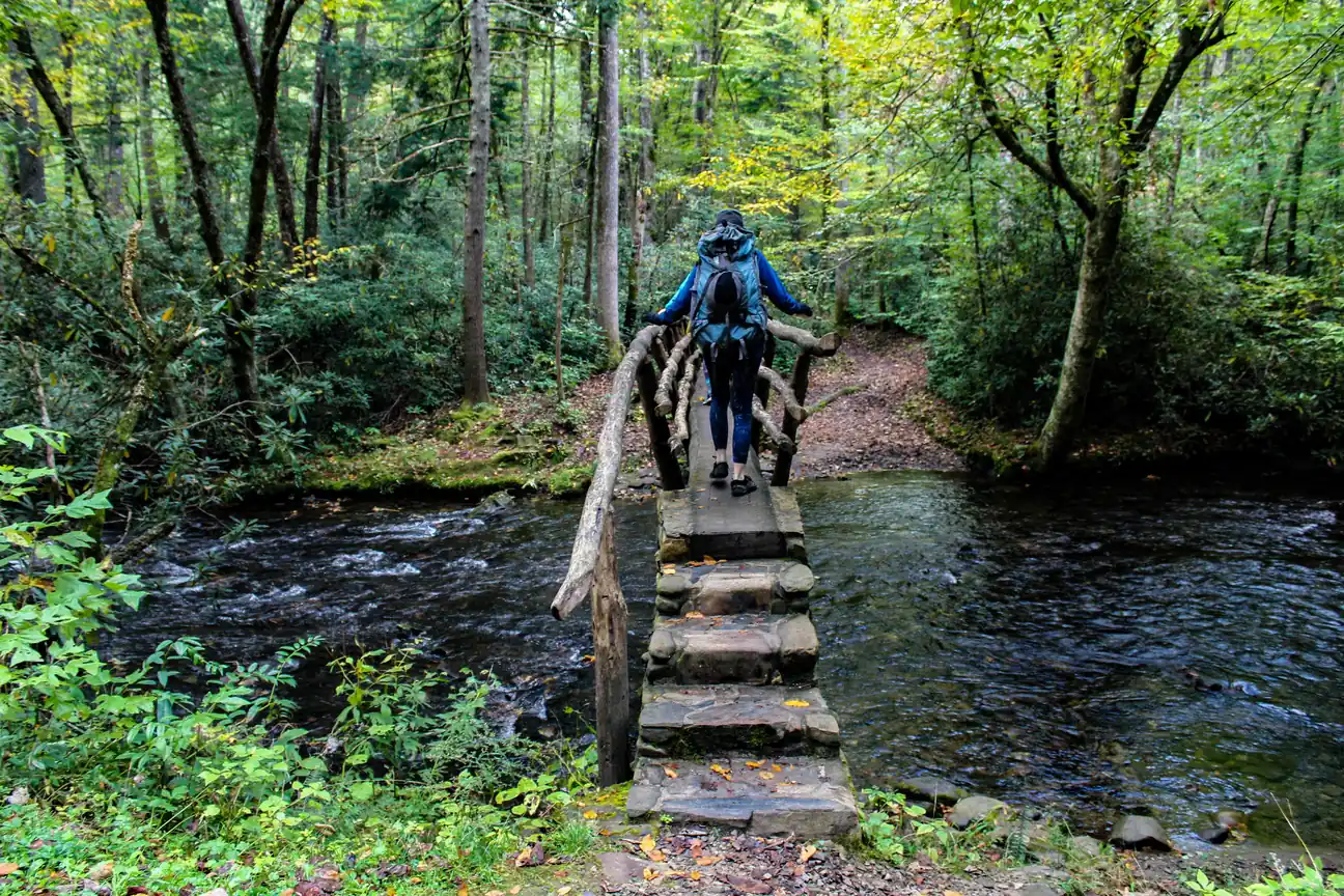 Hiker crossing a wooden footbridge on a Great Smoky Mountains trail