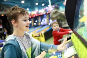 Kids playing arcade games at an amusement center, a fun stop in Gatlinburg